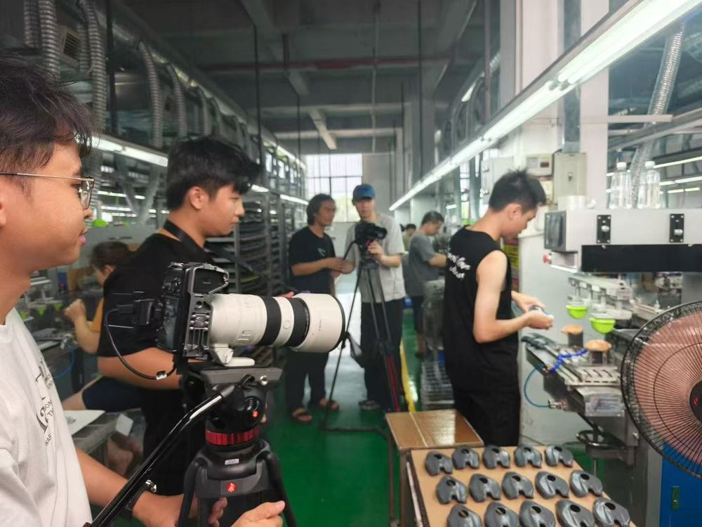 工厂生产线旁的产品与流程拍摄现场,摄影机和工作人员正在进行画面准备